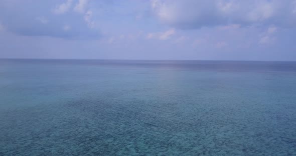 Natural birds eye travel shot of a paradise sunny white sand beach and blue water background in colo