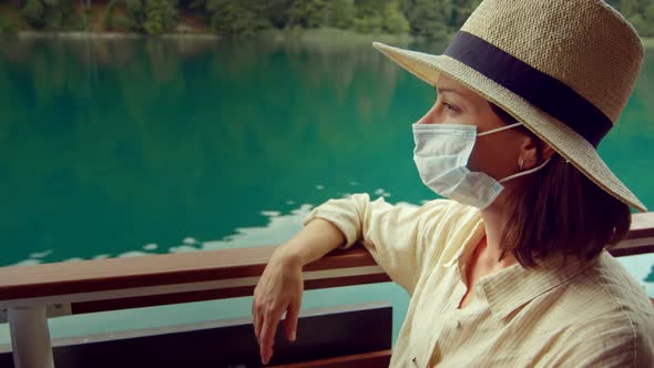 Young woman in medical mask on a ship in National Park