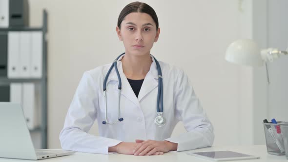 Serious Female Doctor in Clinic Looking at the Camera 