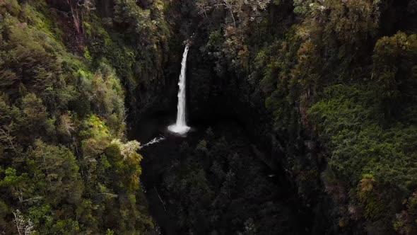 flying towards huge waterfall surrounded by forest drone aerial