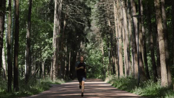 Young Handsome Man Running Marathon in City Park