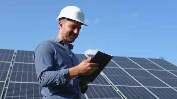 Engineer Solar Photovoltaic Panels Station Checks with Tablet Computer