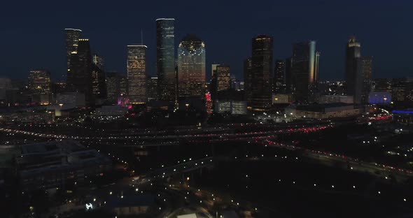 This video is about an aerial view of downtown Houston at night with traffic going pass downtown. Th