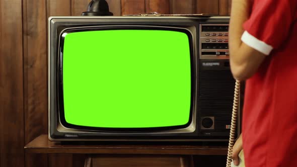 Teenage Boy talking on Old Telephone and Watching Retro TV Green Screen.