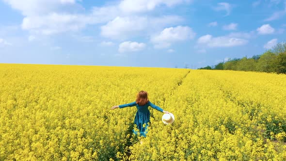 Happy Girl Running Through The Rapeseed Field
