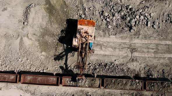 Large Excavator Loads Rock Formation to the Freight Train