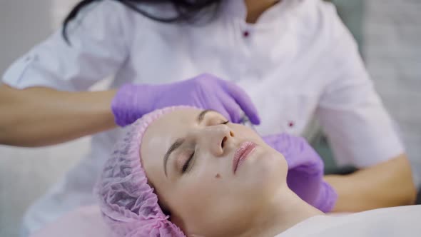 A beautiful woman is lying on a couch with at the cosmetologist on a mesotherapy procedure