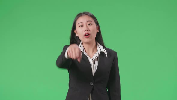 An Angry Asian Business Woman Scolding While Standing On Green Screen In The Studio