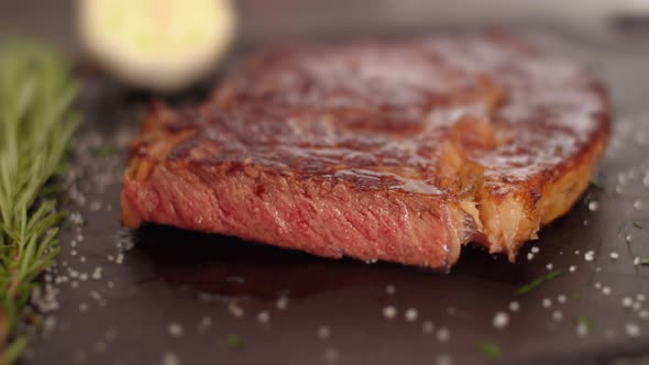 Medium Rare Beef Steak Be on a Cutting Board with Salt and a Sprig of Rosemary. Delicious Beef Steak