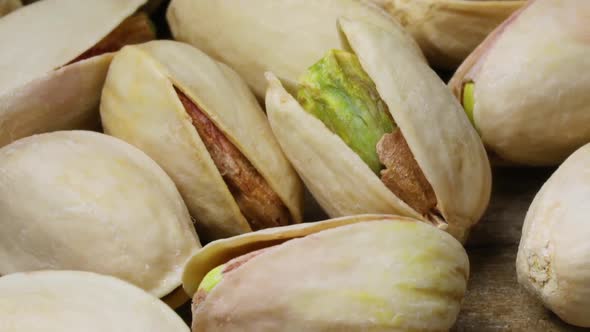 Salted roasted pistachio nuts full frame with a peeled one in front