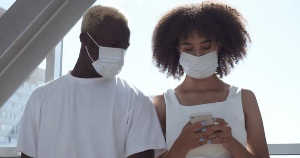 African American Couple of Two Young Teenagers Wear Protective Medical Masks on Their Faces, Stand