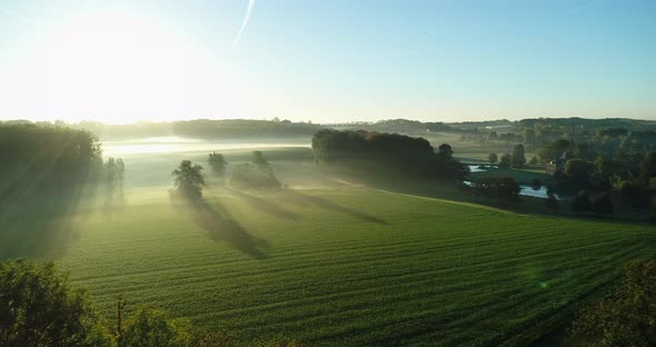 AERIAL: Sunrise over a misty countryside on a beautiful morning.