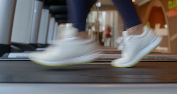 Woman legs run on the treadmill in gym room