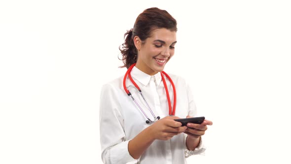 Portrait of a Young Smiling Nurse Using Her Smartphone to Text Messages