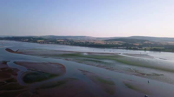 Flying over the ocean off of the shores of an historical town in southwest England. The water is cal