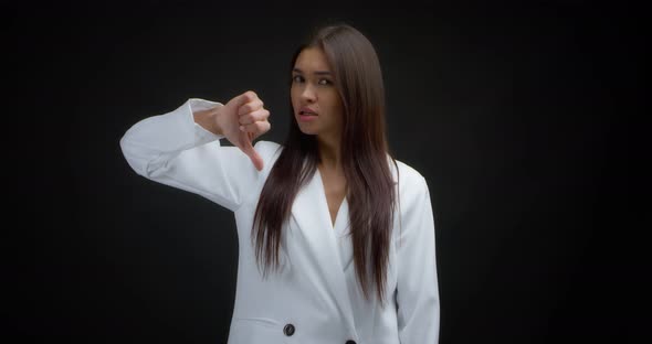 Disgruntled Woman Shows a Sign of Disapproval Lowers Her Thumb