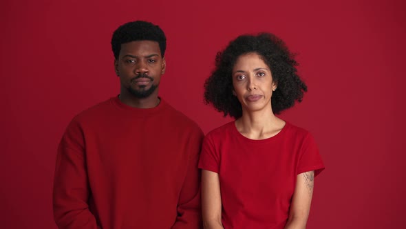 Displeased African couple showing silence gesture