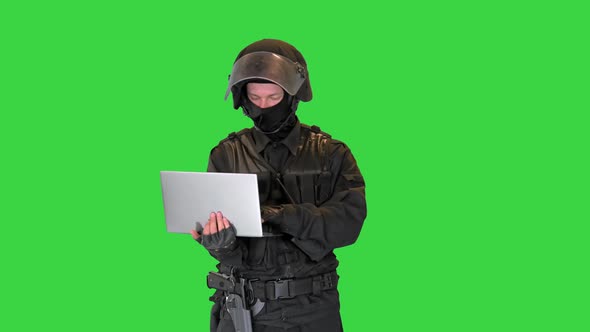 Masked Police Officer Using a Laptop Computer on a Green Screen Chroma Key