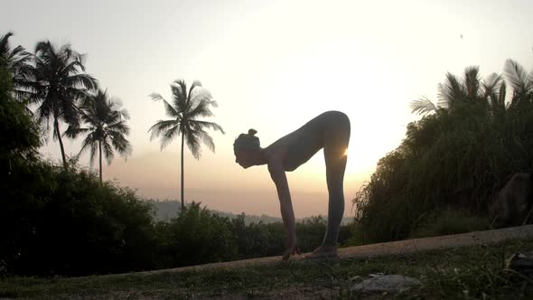 Yoga Teacher Bends Body To Knees at Sunrise Slow Motion