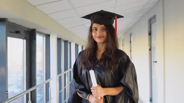 Indian Female Graduate in Black Gown and Wearing Master's Hat in University