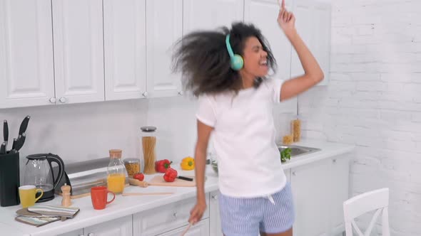 Woman Preparing Salad in The Kitchen. She Listening to Music, Dancing and Singing. 