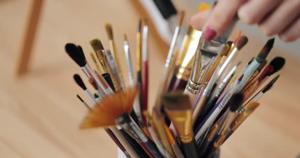 Close Up of Female Hands Choosing Brushes for Painting