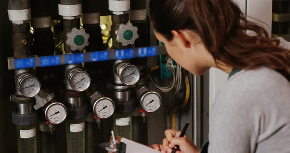 Female engineer maintaining record in clipboard