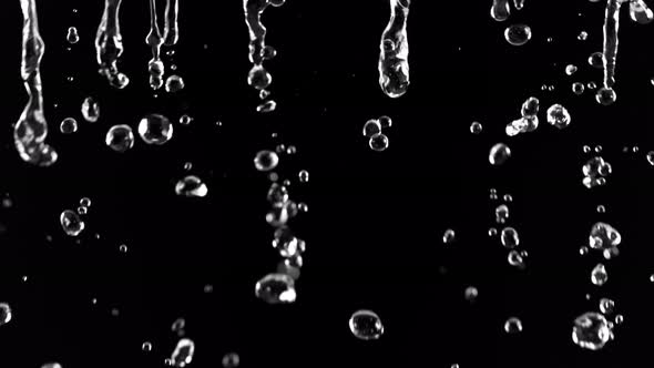 Super Slow Motion Shot of Falling Water Droplets Isolated on Black Background at 1000fps.