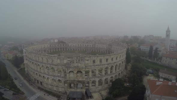 Aerial view of Pula Arena on a foggy day