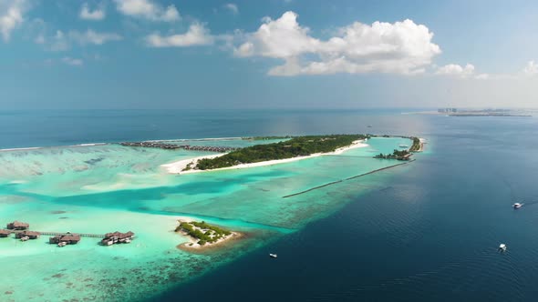 Aerial Video Above Tropical Resorts in Turquoise Lagoon with Water Villas