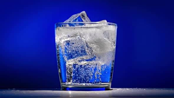 Glass of Water with Ice on a Dark Blue Background