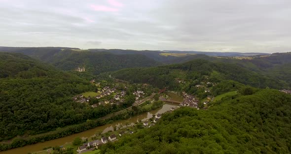 Drone Overview of a German Village at a river with forest and hills surrounding.