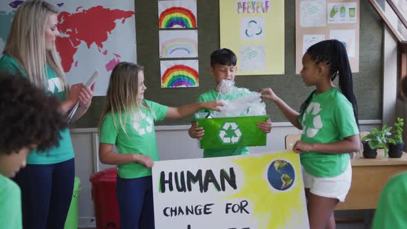 Group of kids holding climate change banner and recycle container at school