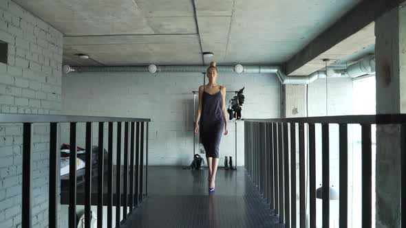 Female Model Walks Along Dark Catwalk in Her Shoes at Home and Shows an Outfit