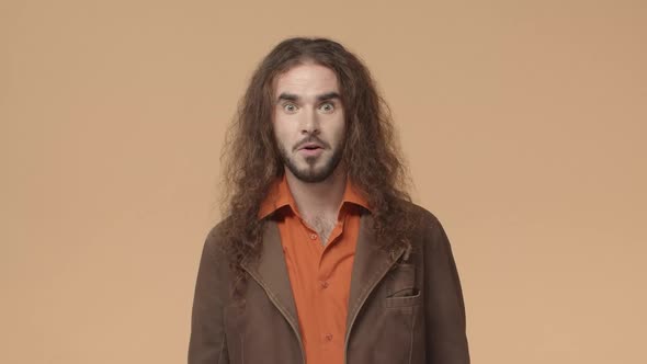 Impressed Hippie Hipster Guy with Long Curly Hair and Beard Look Astonished and Surprised Nod