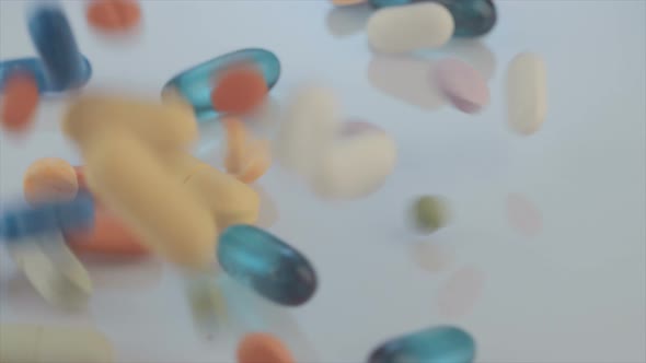 Slow motion of Prescription drugs - Capsules, pills, tablets falling on reflective background