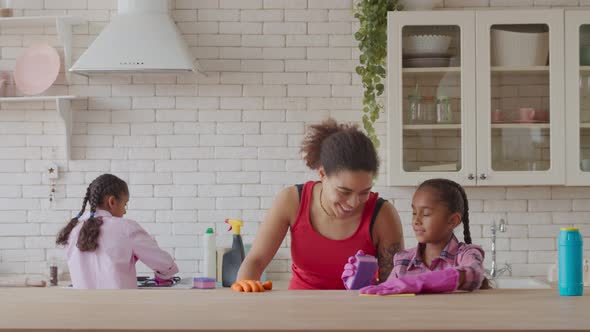 Two Little Sisters Cleaning Kitchen Helping Mother