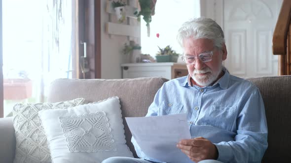Excited elderly man celebrate health insurance deal closing looking and reading the medical results