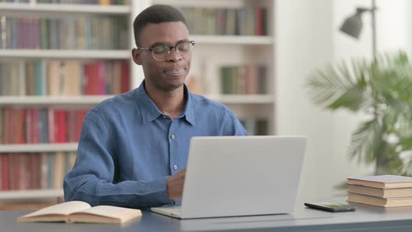 Young African Man Talking on Video Call on Laptop in Office