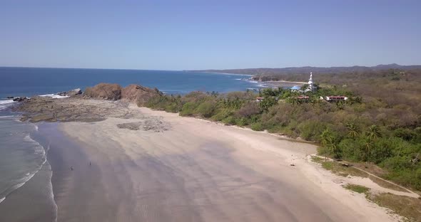 Aerial drone view of the beach, rocks and tide pools in Guiones, Nosara, Costa Rica