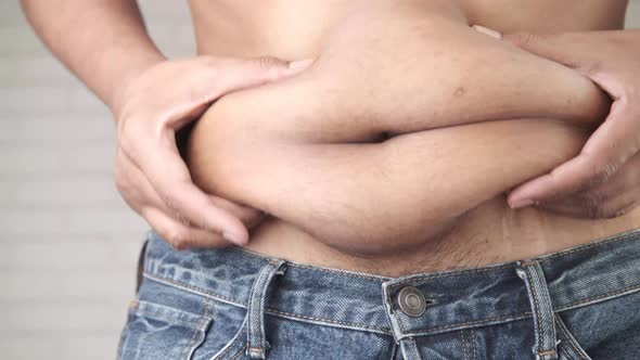 Man's Hand Holding Excessive Belly Fat Overweight Concept