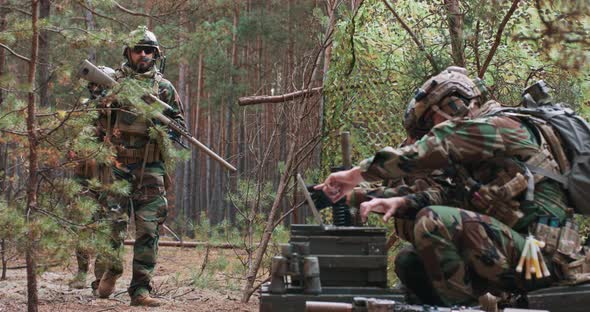 Bearded Soldiers in Woodland Military Uniforms Return From Reconnaissance to a Temporary Base in the