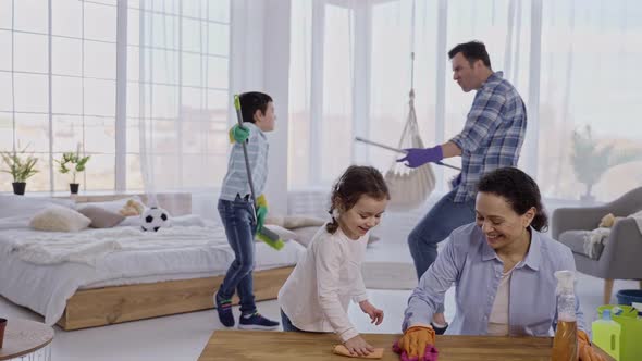 Friendly Family Doing Household Chores with Joy