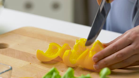 Young Woman Chopping Pepper at Home