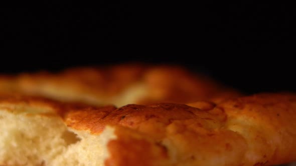 A Bitten Loaf of White Bread Spins Closeup on a Black Background
