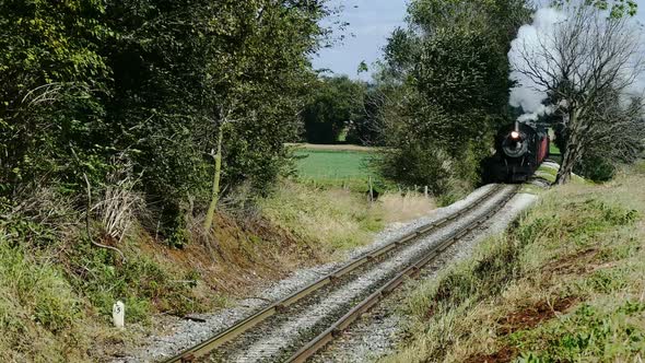 Steam Passenger Train Puffing Along Amish Farm lands and Countryside