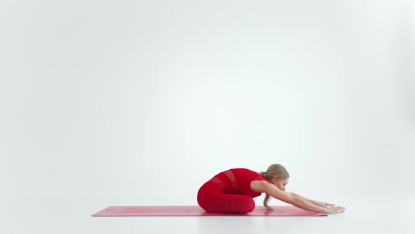 Beautiful Young Woman Wearing Red Sportswear Doing Yoga or Pilates Exercise Pose on White Background