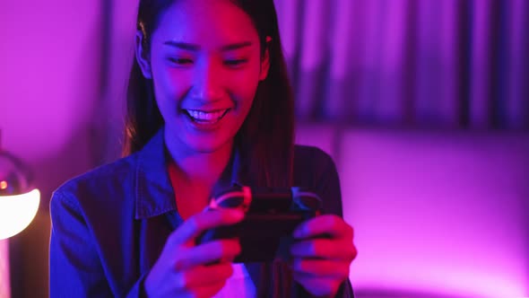 Young asian woman is using virtual reality headset. Neon light studio portrait.