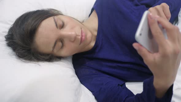 Hispanic Woman Using Smartphone at Night, Scrolling Screen