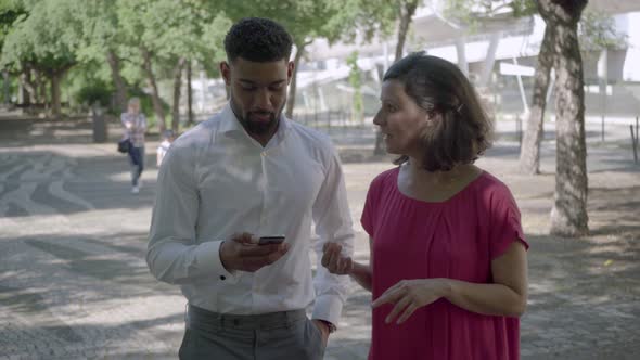 Two People Walking in Summer Park and Talking